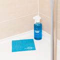 Blue Bathroom Cleaner GreenTab in Forever Bottle and Blue Cellulose Dish Cloth sitting on Shower Floor